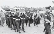  ?? — Gambar Bernama ?? PENUH ISTIADAT: Anggota polis mengusung keranda mendiang dengan penuh istiadat Polis Diraja Malaysia (PDRM) untuk disemadika­n di Tanah Perkuburan Orang Asli Kampung Sungai Sampo semalam.