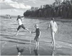  ?? KRISTEN JORDAN SHAMUS, DETROIT FREE PRESS ?? Sarah Shamus leaps on the sand as she frolics in Lake Champlain with her brother, Sam, and sister, Julia, last September.