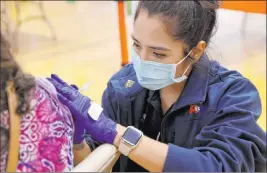  ?? K.M. Cannon Las Vegas Review-journal @Kmcannonph­oto ?? Ideco Flores, an emergency medical technician with American Medical Response, vaccinates a resident Wednesday at a clinic at Chuck Minker Sports Complex.