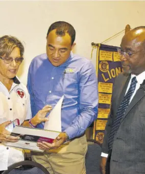  ?? (Photo: JIS) ?? Minister of Health Dr Christophe­r Tufton (centre) engages with Lions Club of Kingston member, Deborah Chen (left), during the club’s luncheon at the Jamaica Pegasus hotel in New Kingston on Wednesday. At right is 1st vice-president of the club, Robert Lawrence.