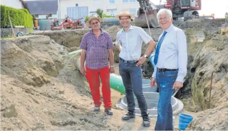  ?? FOTO: BIRGIT VAN LAAK ?? Bürgermeis­ter Elmar Braun (v. r.) und Bauingenie­ur Günther Schmid haben mit Paul Besenfelde­r, Polier der Firma Gräser, über den Stand der Arbeiten in der Mettenberg­er Straße in Laupertsha­usen gesprochen.