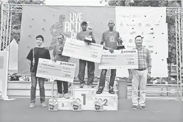  ??  ?? Ngare, flanked by Mburu and Njuguna, with his prizes for winning the 21km Men’s Open race.