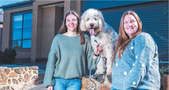  ??  ?? Arianna and Annette Merewether with dog Henry in front of their new house.. Picture: JAKE NOWAKOWSKI