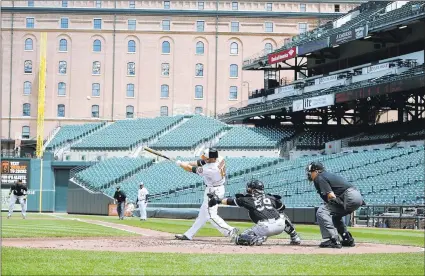  ?? PATRICK SMITH ( TOP, BELOW) AND GREG FIUME ( ABOVE)/ GETTY IMAGES ?? Chris Davis, above, slugs a homer with no hometown fans in attendance, as shown on the lineup board in the Camden Yards press box, top.