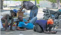  ?? ?? Varias personas se refugian de los disparos durante choques entre la policía y bandas armadas en Puerto Príncipe, Haití.