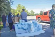  ?? CARLY STONE - MEDIANEWS GROUP ?? Volunteers and Community Action Partnershi­p staff help distribute resources to residents in need. Diapers and baby wipes were on hand along with hygiene products and food.