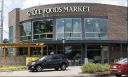  ?? ROGELIO V. SOLIS — THE ASSOCIATED PRESS ?? Customers drive past this Whole Foods Market store in Jackson, Miss., Friday. Amazon is buying Whole Foods Market in a deal valued at $13.7 billion, uniting the on-line giant with the grocery store chain that touts fresh organic foods.