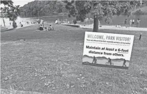  ?? SARA SHIPLEY HILES/KAISER HEALTH NEWS ?? A sign instructs people to maintain a 6-foot distance at Grand Glaize Beach in Missouri’s Lake of the Ozarks State Park.