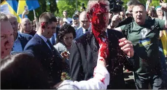  ?? AP ?? SPLASHDOWN: Protestors opposed to the war in Ukraine hurled red paint at Russian ambassador Sergey Andreey as he arrived at a cemetery in Warsaw to pay respects to Red Army soldiers who died during World War II.