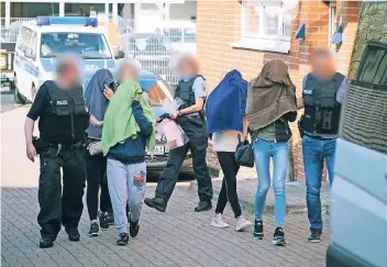  ?? FOTO: DPA ?? Auch in Hannover in Niedersach­sen gab es einen Einsatz: Hier führen Polizisten Frauen aus einem Haus.