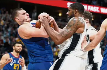  ??  ?? It’s mine!: Denver Nuggets centre Nikola Jokic (left) fighting for control of the ball with San Antonio Spurs forward LaMarcus Aldridge during the NBA game on Friday. The Nuggets won 102-99. — AP