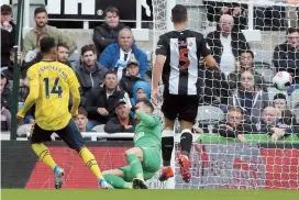  ??  ?? Arsenal striker Pierre-Emerick Aubameyang chips the ball over Newcastle United goalkeeper Martin Dubravka to score the only goal during their English Premier League match at St James’ Park in Newcastle-upon-Tyne, northeast England, yesterday. — AFP