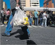  ?? CARLOS GARCIA RAWLINS/REUTERS ?? Escassez. Venezuelan­os enfrentam filas por alimentos