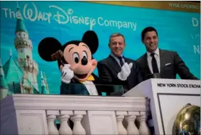  ?? GETTY IMAGES GETTY IMAGES ?? Chief Executive Officer and Chairman of The Walt Disney Company Bob Iger (center) and the company’s popular mascot Chief Executive Mickey Officer Mouse and get Chairman ready to ring of The the Walt opening Disney bell Company at the New Bob York Iger...