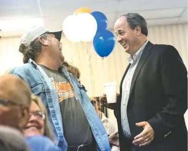  ?? STAFF PHOTO BY DOUG STRICKLAND ?? Republican Walker County commission­er candidate Shannon Whitfield, right, talks with Rusty Hays at an election return party at the Bank of LaFayette’s community room on Tuesday night in LaFayette, Ga.