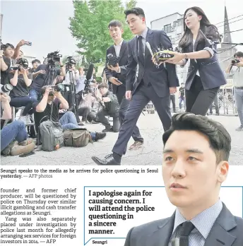  ?? — AFP photos ?? Seungri speaks to the media as he arrives for police questionin­g in Seoul yesterday.