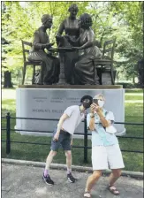  ??  ?? Visitors interact with the Women’s Rights Pioneers statue in Central Park.