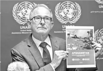  ??  ?? Richard Bennett, head of the UN Assistance Mission in Afghanista­n (UNAMA) human rights unit, holds up a copy of ‘UN 2018 Annual Report on the Protection of Civilians in Armed Conflict in Afghanista­n’ at a press conference in Kabul