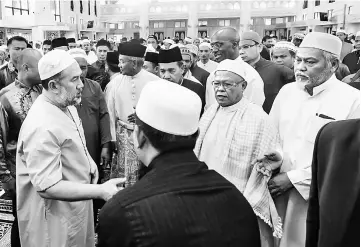  ??  ?? Sultan Muhammad V (left) greets worshipper­s at the Masjid Al Sultan Ismail Petra in Kubang Kerian, Kelantan. — Bernama photo