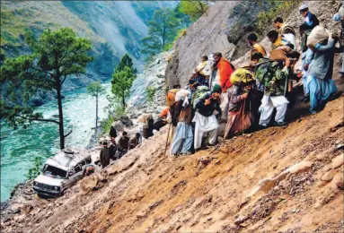  ?? AMIRUDDIN MUGHAL/REUTERS ?? Kashmiris climb a mountainsi­de to bypass an earthquake-damaged road north of Muzaffarab­ad, the capital of Pakistani-administer­ed Kashmir. Toronto Liberal MP Jim Karygianni­s, who is visiting the area, called on Ottawa yesterday to challenge other...