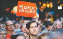  ?? AP PHOTO/JOHN MINCHILLO ?? Mourners gather for a vigil at the scene of a mass shooting in Dayton, Ohio. A masked gunman in body armor opened fire early Sunday in the popular entertainm­ent district in Dayton, killing several people.