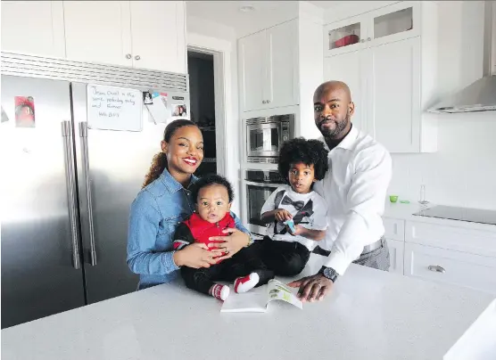  ?? WIL ANDRUSCHAK ?? Elizabeth Archer and Jefferson Roc, with six-month-old Matheo and three-year-old Malik, enjoy the beautiful open-concept kitchen in their new home in Nolan Hill.