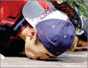  ?? ASSOCIATED PRESS PHOTOS ?? ABOVE: TAKUMA SATO KISSES THE YARD OF BRICKS on the start/finish line after winning the Indianapol­is 500 at Indianapol­is Motor Speedway on Sunday in Indianapol­is. Sato celebrates winning the Indianapol­is 500.