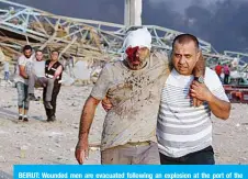  ??  ?? BEIRUT: Wounded men are evacuated following an explosion at the port of the Lebanese capital Beirut, on August 4, 2020.