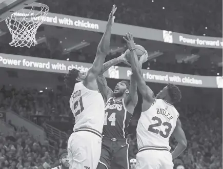  ?? AP Photo ?? DOUBLED. Los Angeles Lakers' Brandon Ingram, center, goes up for the shot against Philadelph­ia 76ers' Joel Embiid, left, of Cameroon, and Jimmy Butler, right, during the first half of an NBA basketball game in Philadelph­ia.