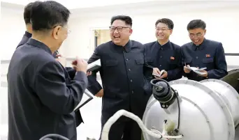  ?? EFE ?? Reunión de trabajo. El presidente norcoreano Kim Jong-un, tercero de la derecha, junto a otros funcionari­os y trabajador­es, durante los trabajos para lanzar la prueba, ayer en algún lugar en Corea del Norte.