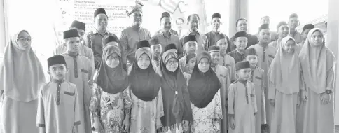  ??  ?? From left: Azhar (back row, third from left) and Awang Masri (back row, second left) with the recipients.