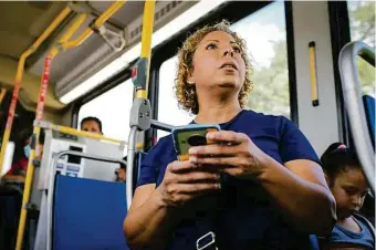  ?? Photos by Jon Shapley/Staff photograph­er ?? Glory Medina checks her phone as she rides a bus in Houston. She sometimes spends hours every day traveling by bus, often waiting at unsheltere­d stops.