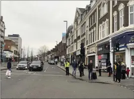  ?? ISOBEL FRODSHAM — PA VIA AP ?? Police attend the scene after an incident in Streatham, London, on Sunday. London police say officers shot a man during a terrorism-related incident that involved stabbings.