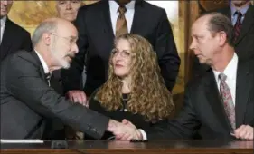  ?? MARC LEVY — THE ASSOCIATED PRESS ?? Pennsylvan­ia Gov. Tom Wolf of Pennsylvan­ia shakes hands with Jim Piazza after signing anti-hazing legislatio­n inspired by Piazza’s son, Penn State student Tim Piazza who died after a night of drinking in a fraternity house, Friday in Harrisburg. Sitting between them is Evelyn Piazza, the mother of Tim Piazza.