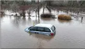  ?? JUSTIN SULLIVAN/GETTY IMAGES ?? A car is submerged in floodwater after heavy rain moved through the area on Jan. 9 in Windsor.