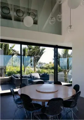  ??  ?? Right The top level pitches out and over the lower level to create a towering eave. Left The ‘Simplice’ dining table by Antonio Citterio for B&B Italia is from Matisse. The ‘DKR2’ dining chairs are by Charles and Ray Eames for Vitra. The pendant lights...