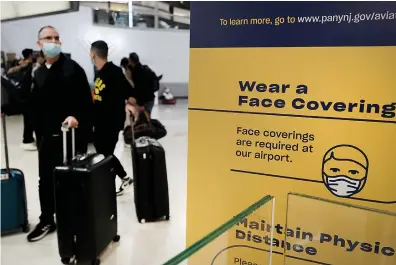  ?? Getty Images/TNS ?? ABOVE: Travelers arrive from
internatio­nal flights, including from South
Africa, at Newark Liberty Internatio­nal Airport on Nov. 30 in Newark, New Jersey.