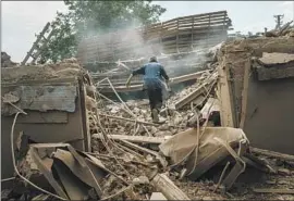  ?? ?? A RESIDENT searches for belongings in a destroyed home. Ukrainian officials estimate that 100 to 200 fighters are killed each day, with many more wounded.