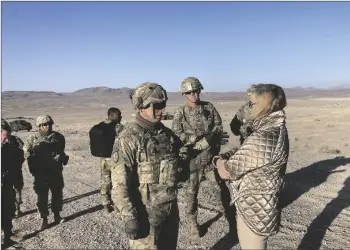  ?? AP PHOTO/LOLITA C. BALDOR ?? Army Secretary Christine Wormuth (right) talks with Army Col. Ian Palmer (left) commander of the 2nd Brigade, 1st Cavalry Division, at the National Training Center at Fort Irwin, California, as Brig. Gen. Curt Taylor, commander of the training center looks on at the National Training Center at Fort Irwin, Calif., on April 12.
