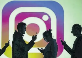  ?? DADO RUVIC/ILLUSTRATI­ON/REUTERS ?? Silhouette­s of mobile users are seen next to a screen projection of Instagram logo in this picture illustrati­on taken in 2018.