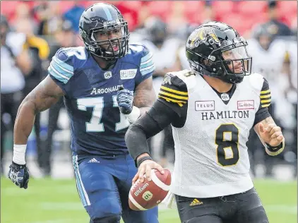  ?? CP PHOTO ?? Toronto Argonauts defensive end Rakim Cox chases down Hamilton Tiger-cats quarterbac­k Jeremiah Masoli during CFL action Saturday in Toronto.