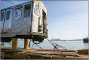  ?? TED SHAFFREY — THE ASSOCIATED PRESS ?? One World Trade Center in Manhattan is visible from a railroad barge carrying retired 1960s-era R-32subway cars through New York Harbor.