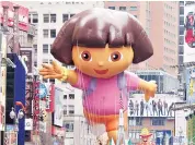  ?? PHOTO: REUTERS ?? Spectators watch as a Dora the Explorer balloon floats down Broadway during a parade in New York.
