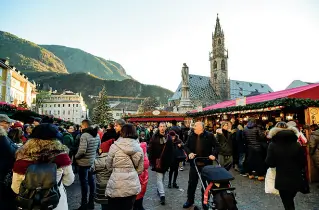  ??  ?? Attrazione Turisti al mercatino di Natale in piazza Walter a Bolzano: quest’anno, se si svolgerann­o, i mercatini verranno totalmente modificati. E potrebbe non esserci più nemmeno il vin brulè