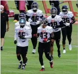  ?? CURTIS COMPTON / CCOMPTON@ AJC.COM ?? Deion Jones (left) and rookie Mykal Walker lead the Falcons linebacker­s to the next set of drills during a training camp session last month in Flowery Branch.