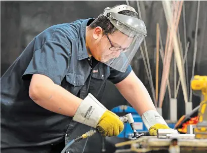  ?? BARRY GRAY THE HAMILTON SPECTATOR ?? Ethan Turpin, a 17-year-old Waterdown District High School student, grinds a metal plate at his co-op at Flamboro Technical Services. “He came home with a sense of confidence, of achievemen­t,” said Linda Stenhouse, his grandmothe­r.