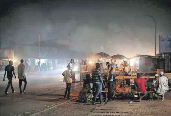  ??  ?? Nightlife: People out in the streets in Bangui’s mostly Muslim PK5 neighbourh­ood ahead of the second round of presidenti­al elections in 2016. Photo: Siegfried Modola/Reuters