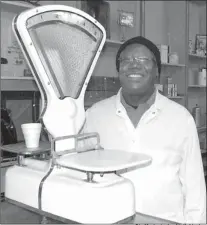  ?? Staff photo by Neil Abeles ?? Arlester Maxie, market manager and 40-year meat cutter for Brookshire’s in Atlanta stands by the butcher’s weigh scales he never needed to use but which represent the close associatio­n of butcher and customer.