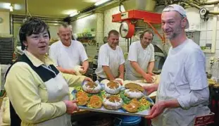  ??  ?? Bäckermeis­ter Norbert Beitz (rechts) und Chefin Christine Rabe mit Exemplaren des neuen Lutherbrot­es und der Lutherbröt­chen. Mit großer Tatkraft gehen Dirk und Lars Bippart sowie Lutz Zscheesche (von links) zu Werke. Foto: Norman Meißner