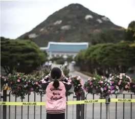  ?? — AFP ?? SEOUL: A girl takes a photo of the presidenti­al Blue House.